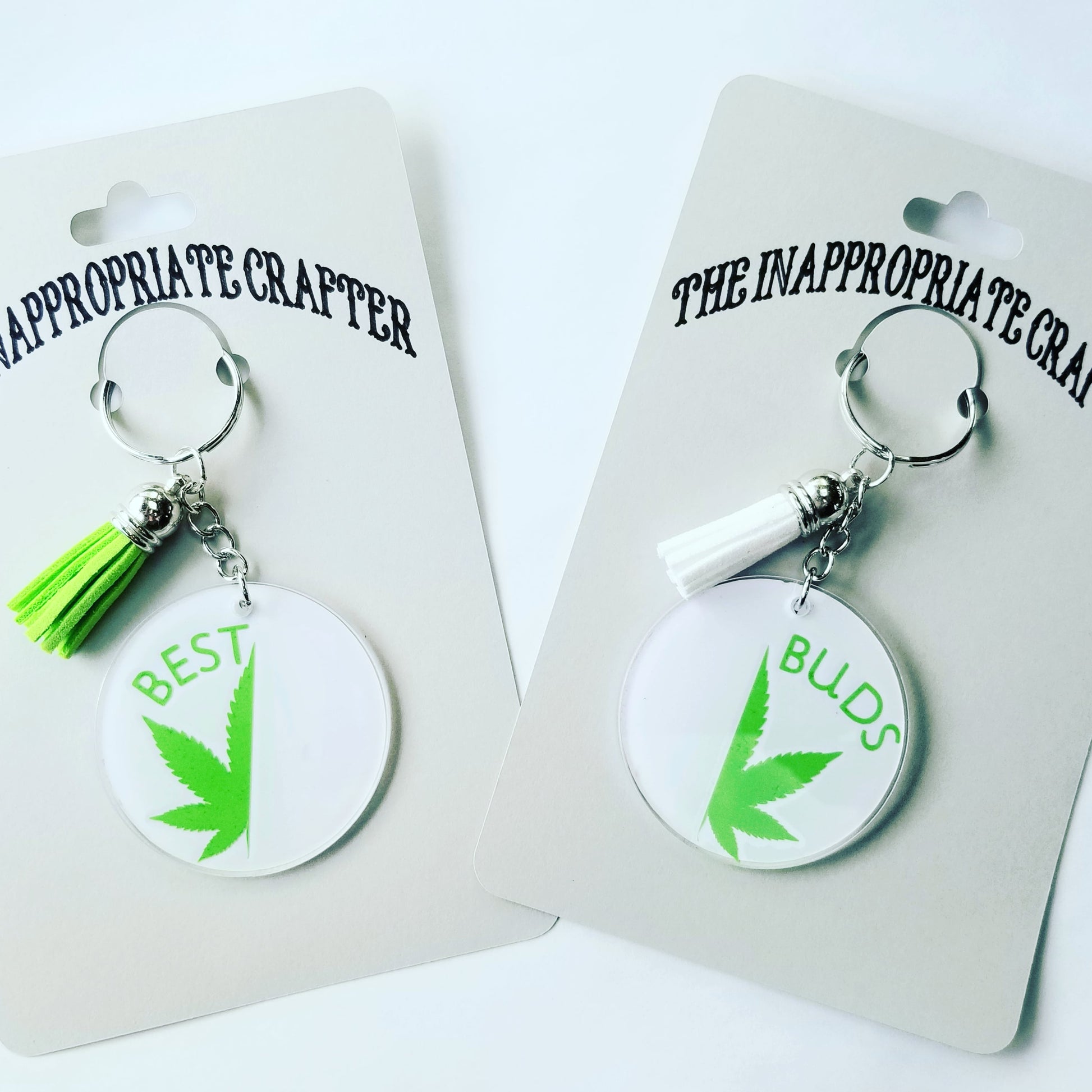 Two white and green keychains each with half marijuana leaf. One keychain says Best and one says Buds. Shown on cards saying The Inappropriate Crafter.