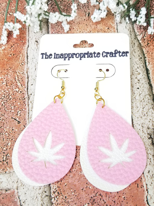 Pair of pink and white faux leather earrings on a card.  Top pink layer features a pot leaf cut out over the bottom white layer.  